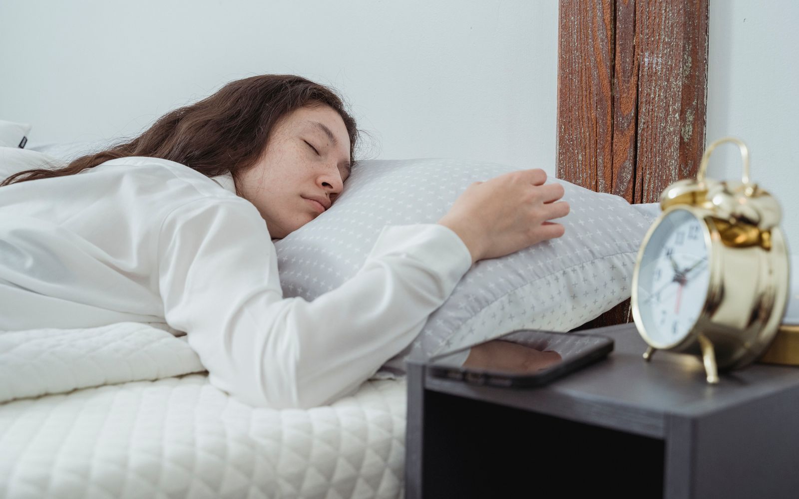Sabah ışığında alarm saatinin yanında uyuyan kadın